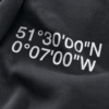 kk-hoodie-london-india-ink-grey-coord-close-fabric Close-up of India ink grey oversized hoodie with London coordinates back print in minimalist typography. Premium heavyweight cotton texture and detailed print finish shown in editorial lighting.