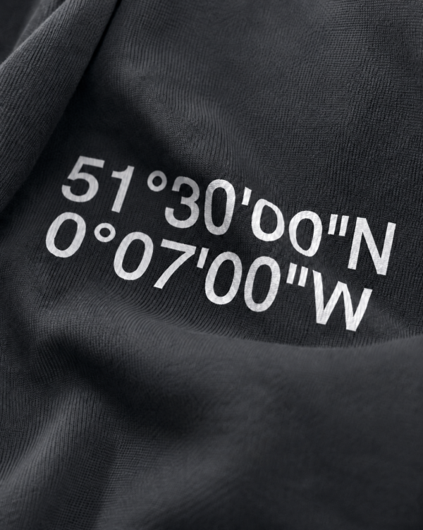 kk-hoodie-london-india-ink-grey-coord-close-fabric Close-up of India ink grey oversized hoodie with London coordinates back print in minimalist typography. Premium heavyweight cotton texture and detailed print finish shown in editorial lighting.