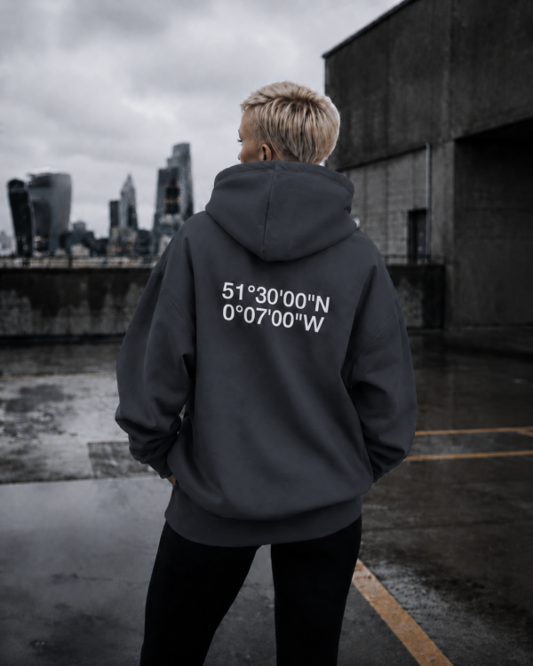 kk-hoodie-london-india-ink-grey-rooftop India ink grey oversized London coordinates hoodie styled on rooftop overlooking London skyline. Minimal streetwear aesthetic with cinematic concrete setting and relaxed oversized fit.