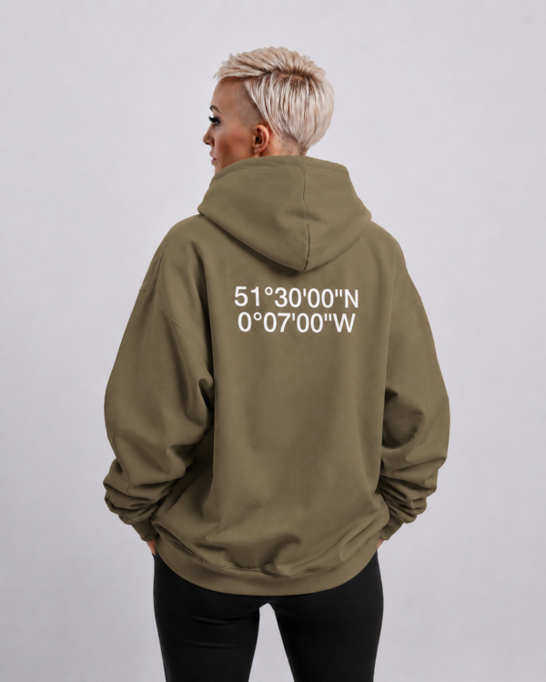 kk-hoodie-london-khaki-body Waist-up fit shot of Khaki oversized hoodie with London coordinates back print. Relaxed oversized silhouette with dropped shoulders and clean minimal streetwear styling.