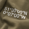 kk-hoodie-london-khaki-close-design Close-up of Khaki oversized hoodie with London coordinates back print in white typography. Heavyweight cotton fabric texture and premium print detail shown in soft editorial lighting.