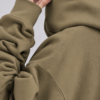 kk-hoodie-london-khaki-close-fabric Detailed fabric close-up of Khaki oversized streetwear hoodie showing heavyweight cotton texture, shoulder seam construction, ribbed cuff, and premium minimal finish.