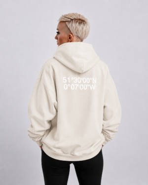 Waist-up fit shot of Natural Raw oversized hoodie with London coordinates back print. Clean oversized silhouette with dropped shoulders and minimal streetwear styling.