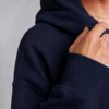 Close-up detail of premium french navy heavyweight hoodie fabric showing ribbed cuff texture, structured stitching, and soft brushed cotton finish with minimal luxury streetwear aesthetic.