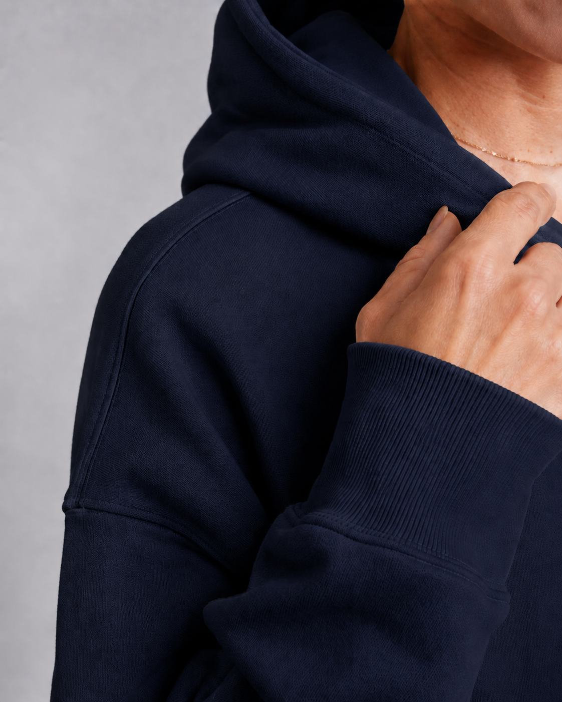 Close-up detail of premium french navy heavyweight hoodie fabric showing ribbed cuff texture, structured stitching, and soft brushed cotton finish with minimal luxury streetwear aesthetic.