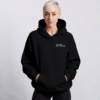 kk-hoodie-not-loud-just-powerful-front-logo-black Front view of oversized black minimalist hoodie with subtle white “NOT LOUD JUST POWERFUL” chest logo, heavyweight premium fabric, kangaroo pocket, and relaxed modern streetwear fit against a neutral studio background.