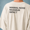kk-tee-minimal-noise-max-impact-back-print-natural-raw1 Rear view of a model wearing a natural raw oversized T-shirt featuring the statement “MINIMAL NOISE MAXIMUM IMPACT” printed in large white lettering across the back. Soft studio lighting emphasizes the premium heavyweight cotton and relaxed silhouette.