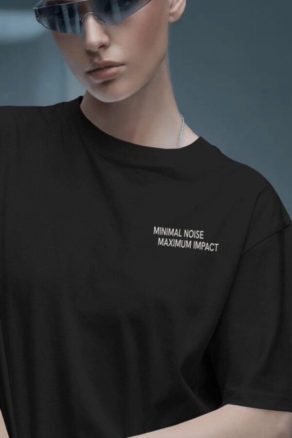 Minimal black oversized streetwear t-shirt with small chest typography print styled in futuristic editorial fashion portrait