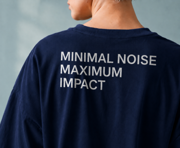 Detailed close-up of oversized French navy t-shirt back print reading “MINIMAL NOISE MAXIMUM IMPACT” showing premium fabric texture and oversized fit