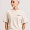 Close-up portrait of a model wearing a natural raw oversized Kat Krush T-shirt featuring the “Not Loud Just Powerful” chest print, highlighting the relaxed fit and premium fabric texture.
