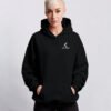 Black oversized Kat Krush hoodie with subtle white chest logo. Relaxed fit with kangaroo pocket and heavyweight streetwear silhouette.