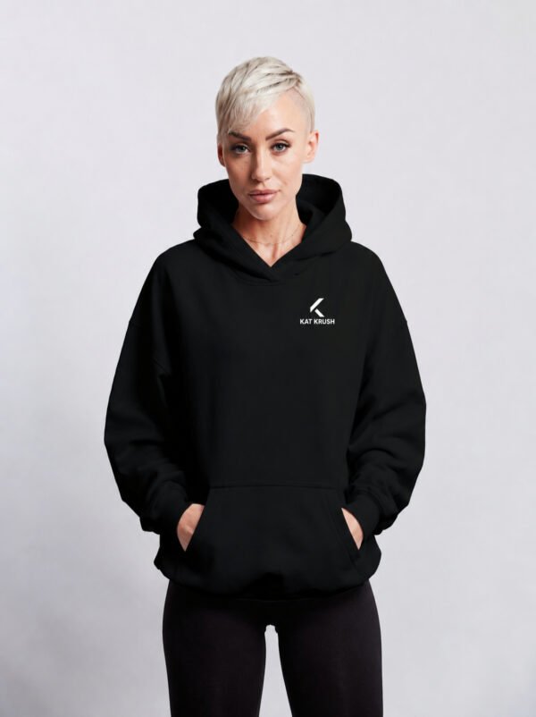 Black oversized Kat Krush hoodie with subtle white chest logo. Relaxed fit with kangaroo pocket and heavyweight streetwear silhouette.