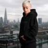 Black oversized Kat Krush hoodie with lilac chest logo styled on a London rooftop overlooking the city skyline. Minimal streetwear aesthetic with relaxed oversized fit.