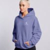 Female model in a violet oversized Kat Krush hoodie, shown from a relaxed side angle with hands in pockets.