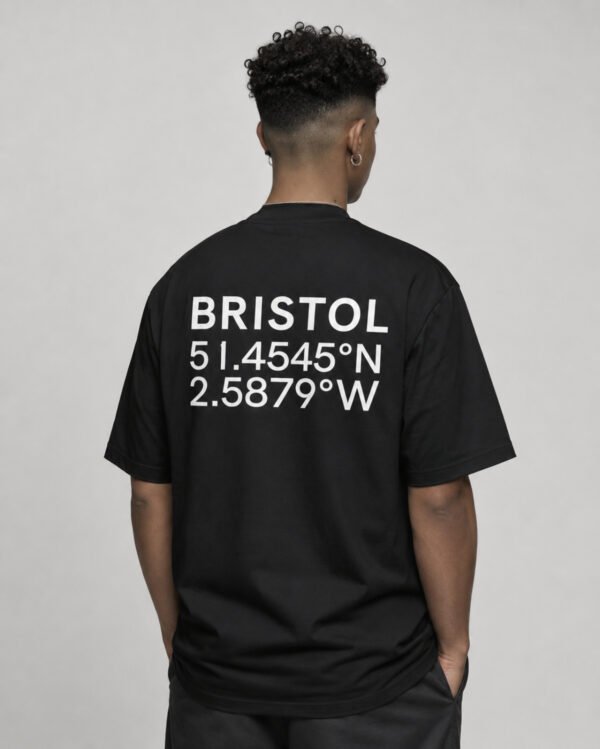kk-tee-bristol-black-back-waist-up-coordinates Waist-up rear view of a black oversized Bristol coordinates T-shirt displaying the city name and coordinate print on the back.