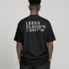Black oversized Leeds coordinates T-shirt featuring Leeds city coordinates printed on the back, worn by a model in a relaxed studio setting.