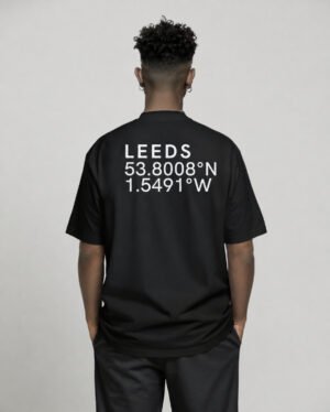 Black oversized Leeds coordinates T-shirt featuring Leeds city coordinates printed on the back, worn by a model in a relaxed studio setting.