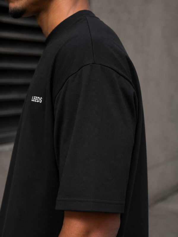 Detailed view of the shoulder and sleeve fabric on a black Leeds coordinates T-shirt, showcasing heavyweight cotton construction.