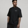 Black oversized Leeds T-shirt with small Leeds chest logo, worn by a model in a relaxed pose against a neutral studio background.