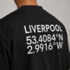Close-up of Liverpool coordinates graphic printed on the back of a black oversized T-shirt, highlighting the clean white typography.