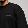 Close-up of the Birmingham Signature chest print on a black oversized heavyweight T-shirt showing premium cotton fabric and clean white coordinates design.