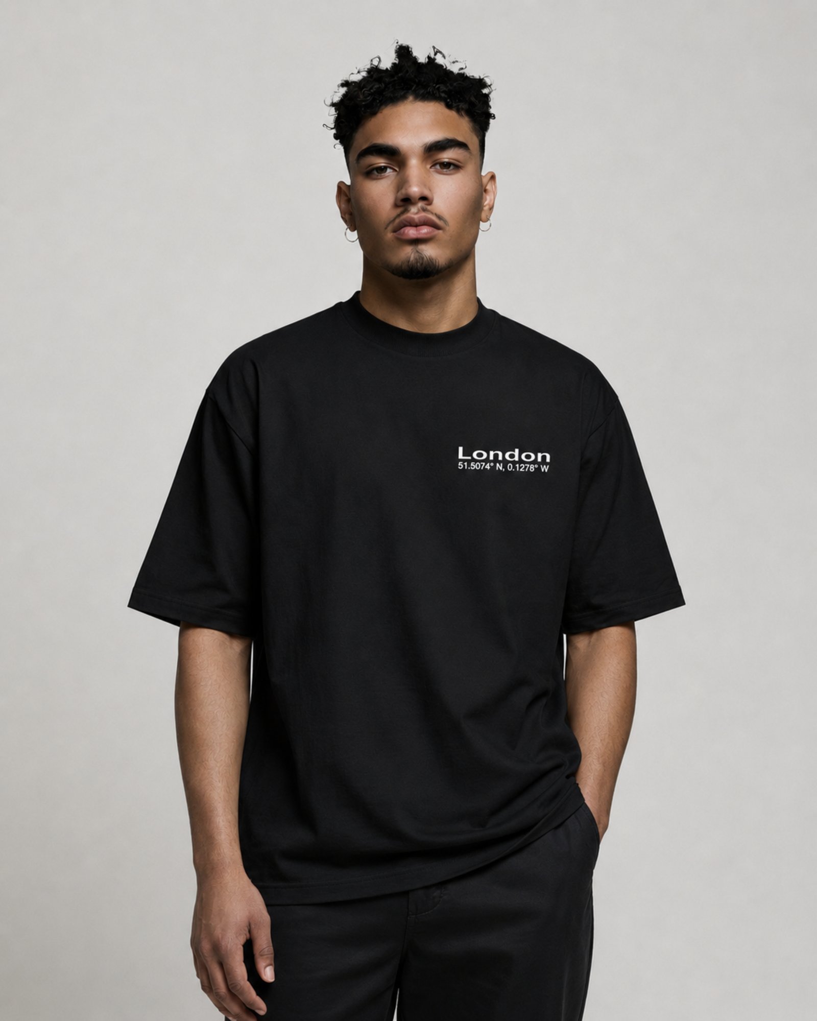 Male model wearing a black oversized London Signature coordinates T-shirt with white chest print, heavyweight premium streetwear and relaxed silhouette.