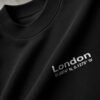 Close-up of London Signature coordinates chest print on black heavyweight oversized T-shirt showing crisp DTG print quality and premium cotton fabric.