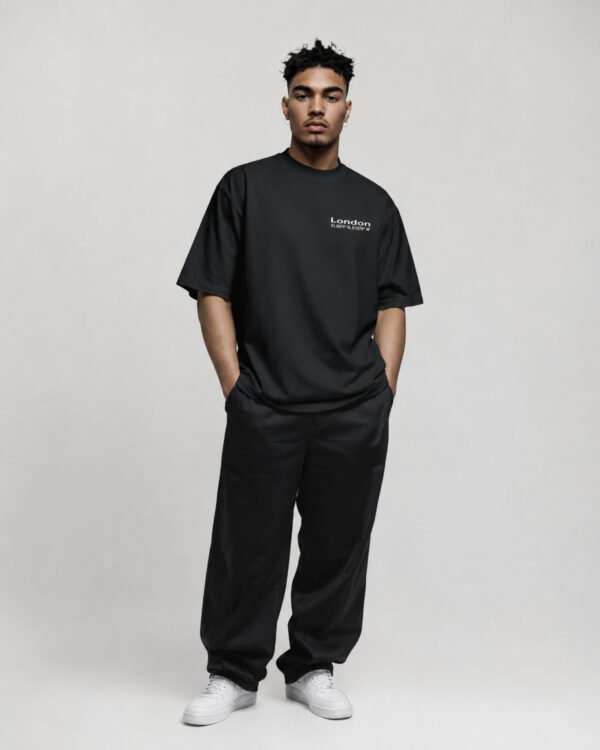 Angled view of black oversized London Signature coordinates T-shirt showing minimalist London coordinates chest print, premium heavyweight fabric and oversized fit.