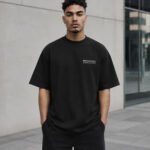 Manchester-Signature-Tee-BLK-hero-urban Model wearing a black Manchester Signature oversized heavyweight T-shirt with a subtle white left-chest Signature design.