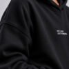 Close-up of the black Kat Krush oversized hoodie showcasing heavyweight premium fabric, dropped shoulder construction and minimalist "Not Loud Just Powerful" chest print.
