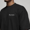 Close-up of the Bristol Signature chest print on a black oversized heavyweight T-shirt showing premium heavyweight cotton fabric and clean white coordinates design.