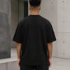 Rear view of a male model wearing a black Bristol Signature oversized heavyweight T-shirt with dropped shoulders and clean minimalist design