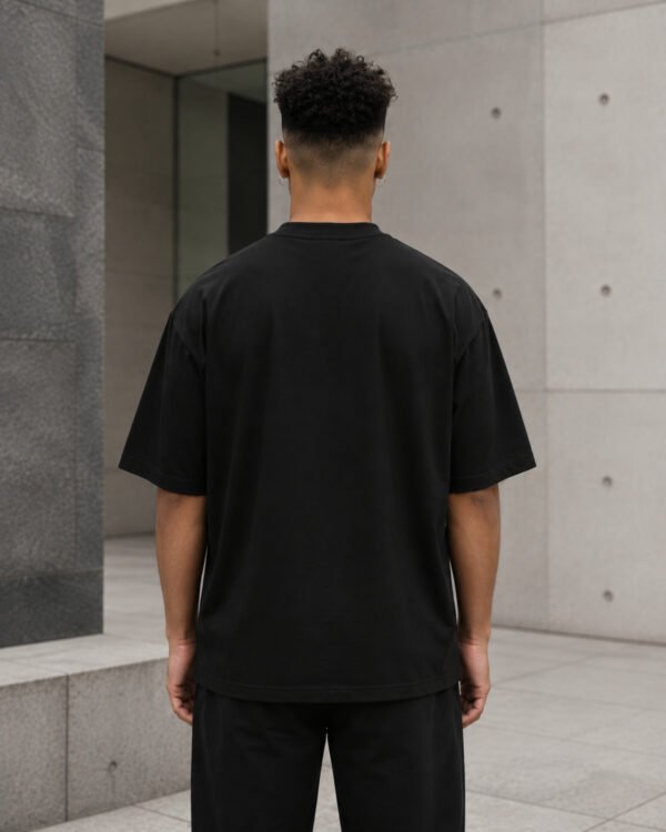 Rear view of a male model wearing a black Bristol Signature oversized heavyweight T-shirt with dropped shoulders and clean minimalist design