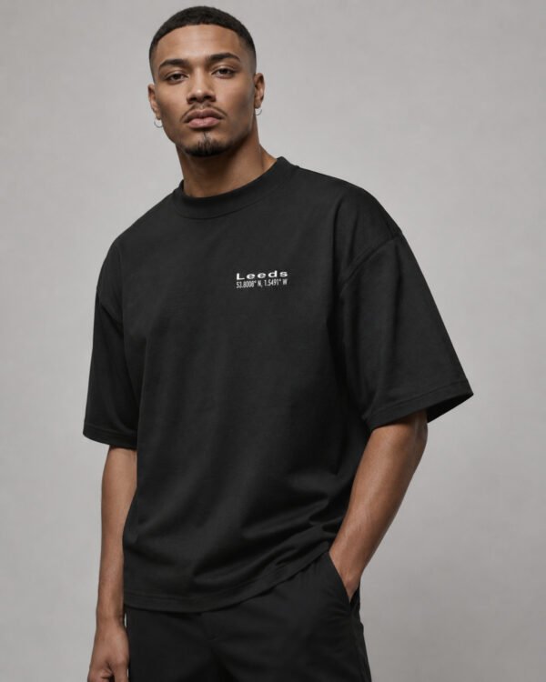 Male model wearing a black Leeds Signature oversized heavyweight T-shirt with a subtle white Leeds coordinates chest design.
