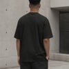 Rear view of a male model wearing the black Leeds Signature oversized T-shirt, showing its relaxed oversized silhouette.