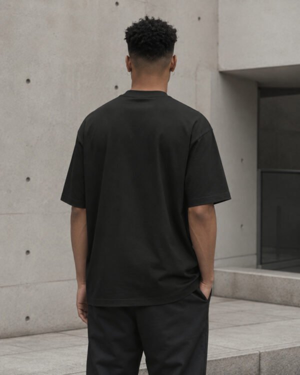 Rear view of a male model wearing the black Leeds Signature oversized T-shirt, showing its relaxed oversized silhouette.