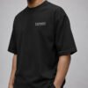 Male model wearing a black Liverpool Signature oversized heavyweight T-shirt featuring a minimalist white left chest coordinates print.