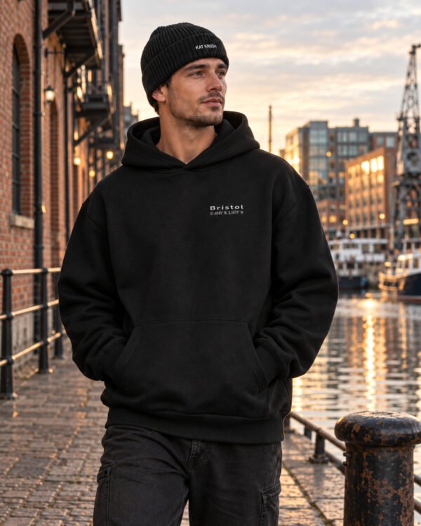 Male model wearing black Kat Krush fisherman beanie and black Bristol Signature heavyweight hoodie at Bristol harbourside