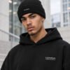 Close-up of male model wearing black Kat Krush fisherman beanie and black London Signature heavyweight hoodie