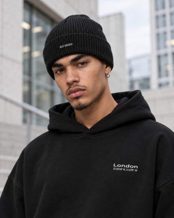 Close-up of male model wearing black Kat Krush fisherman beanie and black London Signature heavyweight hoodie