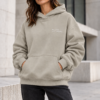 kk stone Hoodie Urban Editorial Portrait Female model wearing Kat Krush Not Loud Just Powerful stone oversized hoodie with relaxed charcoal trousers against modern concrete architecture.